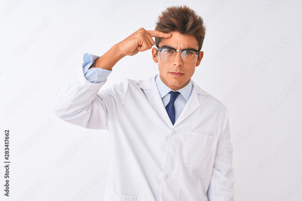 Young handsome sciencist man wearing glasses and coat over isolated white background pointing unhappy to pimple on forehead, ugly infection of blackhead. Acne and skin problem Young handsome sciencist man wearing glasses and coat over isolated white background pointing unhappy to pimple on forehead, ugly infection of blackhead. Acne and skin problem