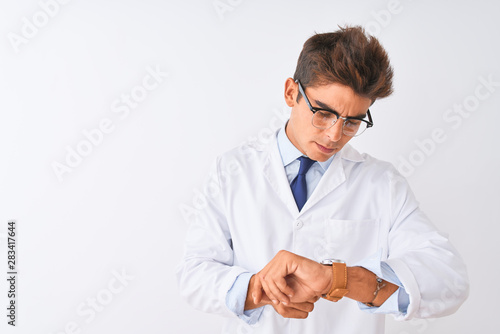 Young handsome sciencist man wearing glasses and coat over isolated white background Checking the time on wrist watch, relaxed and confident © Krakenimages.com