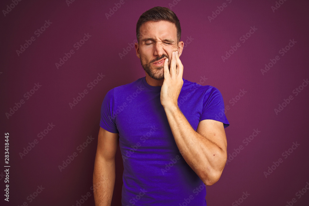Young man wearing casual purple t-shirt over lilac isolated background touching mouth with hand with painful expression because of toothache or dental illness on teeth. Dentist concept. Young man wearing casual purple t-shirt over lilac isolated background touching mouth with hand with painful expression because of toothache or dental illness on teeth. Dentist concept.
