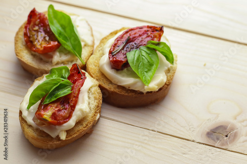 Tasty  with sun-dried tomatoes on wooden table