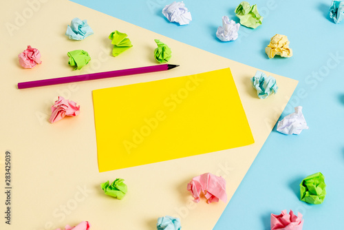 Colored crumpled papers empty reminder blue yellow background clothespin