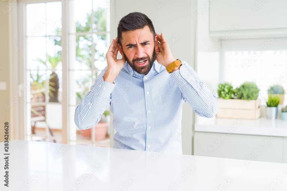 Fototapeta premium Handsome hispanic business man Trying to hear both hands on ear gesture, curious for gossip. Hearing problem, deaf