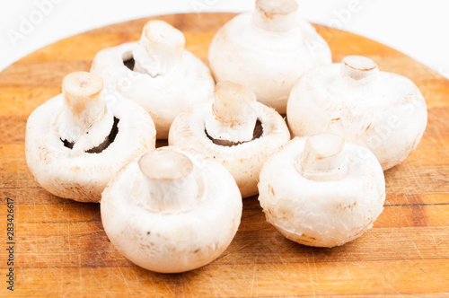 Mushrooms on wooden board isolated on white background. Healthy food.Copy space