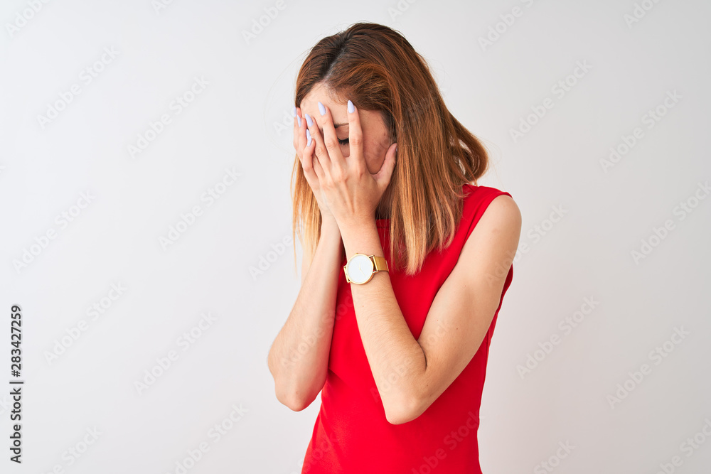 Redhead businesswoman wearing elegant red dress standing over isolated white background with sad expression covering face with hands while crying. Depression concept. Redhead businesswoman wearing elegant red dress standing over isolated white background with sad expression covering face with hands while crying. Depression concept.