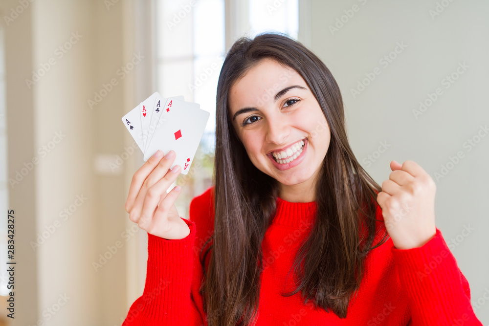 Beautiful young woman gambling playing poker screaming proud and celebrating victory and success very excited, cheering emotion Beautiful young woman gambling playing poker screaming proud and celebrating victory and success very excited, cheering emotion