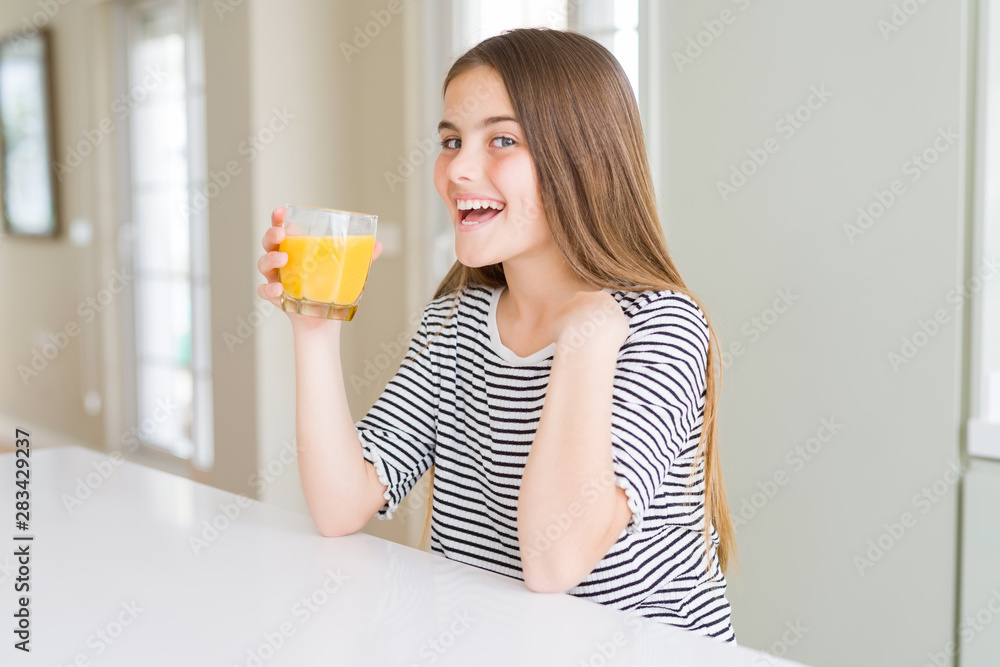 Beautiful young girl kid drinking a glass of fresh orange juice with surprise face pointing finger to himself Beautiful young girl kid drinking a glass of fresh orange juice with surprise face pointing finger to himself