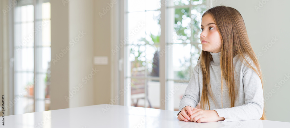 Wide angle picture of beautiful young girl kid wearing casual sweater looking to side, relax profile pose with natural face with confident smile. Wide angle picture of beautiful young girl kid wearing casual sweater looking to side, relax profile pose with natural face with confident smile.