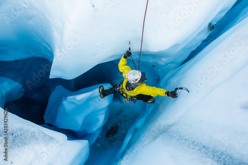 Ice climber on piller inside vertical ice cave on the Matanuska Glacier.