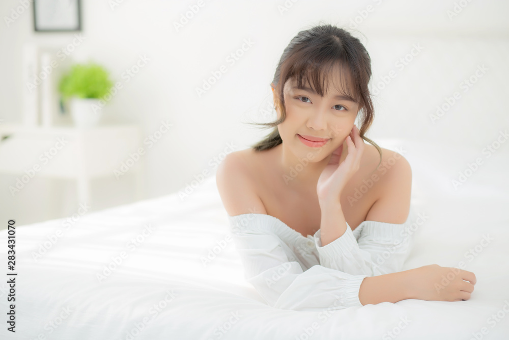 Beautiful portrait young asian woman lying and smile while wake up with sunrise at morning, beauty cute girl happy and cheerful resting on bed in the bedroom, lifestyle and relax concept. Beautiful portrait young asian woman lying and smile while wake up with sunrise at morning, beauty cute girl happy and cheerful resting on bed in the bedroom, lifestyle and relax concept.