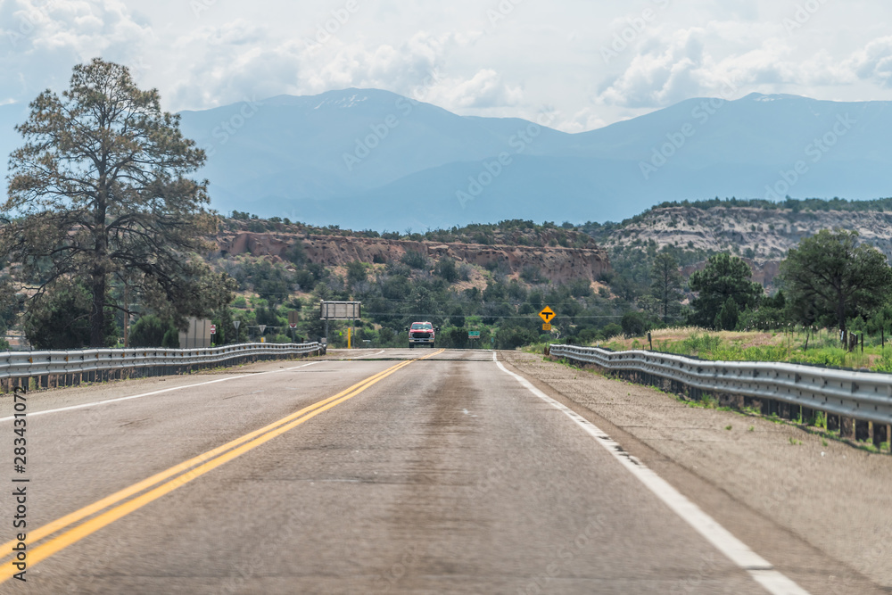 Naklejka premium Road by Santa Fe and Los Alamos, USA near Bandelier National Monument in New Mexico on highway street 502 east with view of mountains