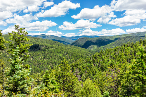 Carson National Forest with Sangre de Cristo mountains and green pine trees in summer and peak overlook from route 76 high road to Taos