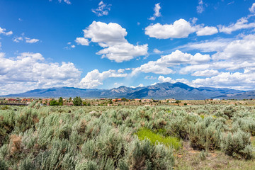 Leinwandbilder Olivgrün View of Taos Sangre de Cristo mountains view from Ranchos de Taos valley and green landscape in summer with clouds  © Kristina Blokhin
