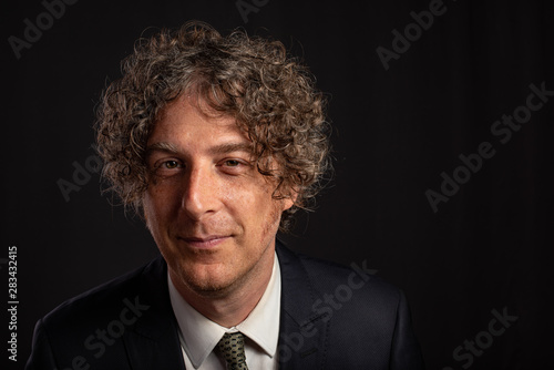 Bilde på lerret Portrait of attractive man in his forties against a dark background
