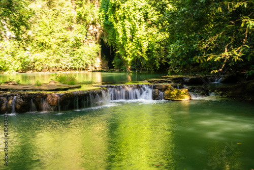 Waterfall in deep tropical rainforest with green tree