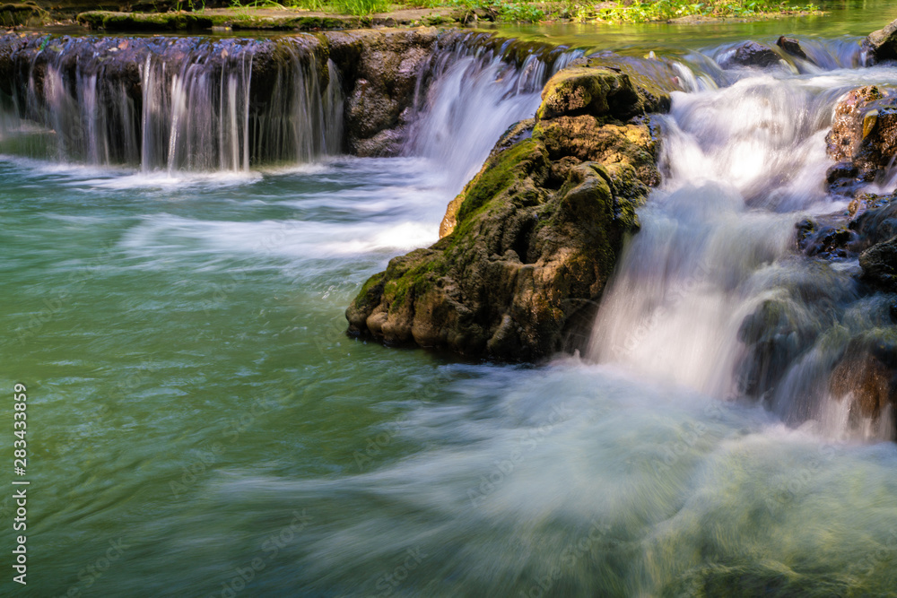 Waterfall in deep tropical rainforest with green tree