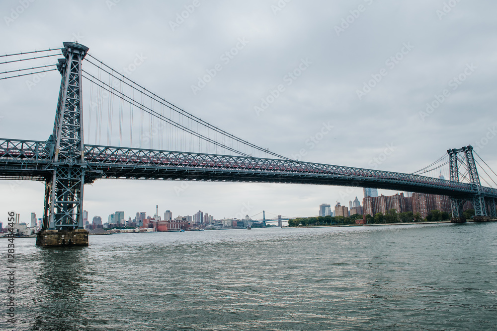 Fototapeta premium View on Williamsburg bridge and Manhattan downtown from Domino Park in Williamsburg, Brooklyn