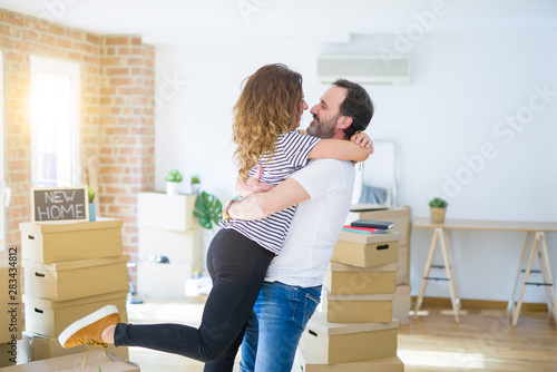 Middle age senior couple moving to a new house, smiling happy in love with apartmant