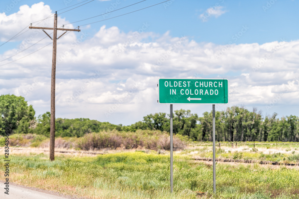 Highway 285 with sign for oldest church in Colorado in old vintage town called Conejos near Antonito