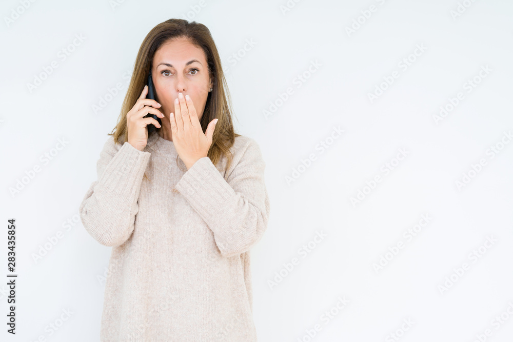 Middle age woman talking on smartphone over isolated background cover mouth with hand shocked with shame for mistake, expression of fear, scared in silence, secret concept Middle age woman talking on smartphone over isolated background cover mouth with hand shocked with shame for mistake, expression of fear, scared in silence, secret concept