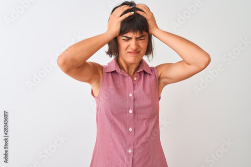 Young beautiful woman wearing red summer shirt standing over isolated white background suffering from headache desperate and stressed because pain and migraine. Hands on head. © Krakenimages.com