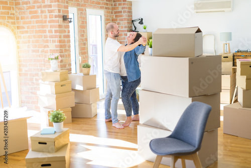 Young couple dancing around cardboard boxes at new home, celebrating smiling very happy new house © Krakenimages.com