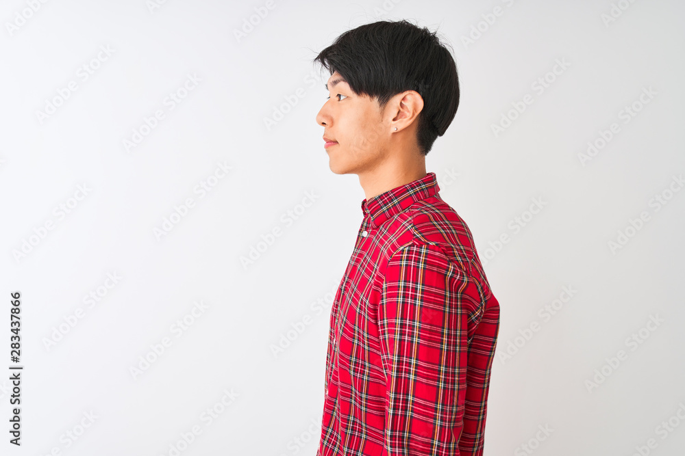 Young chinese man wearing casual red shirt standing over isolated white background looking to side, relax profile pose with natural face with confident smile. Young chinese man wearing casual red shirt standing over isolated white background looking to side, relax profile pose with natural face with confident smile.