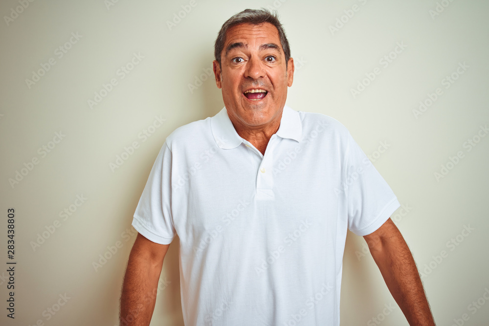 Handsome middle age man wearing polo standing over isolated white background afraid and shocked with surprise expression, fear and excited face. Handsome middle age man wearing polo standing over isolated white background afraid and shocked with surprise expression, fear and excited face.