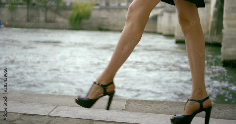 closeup view of slender legs of young fashion model shod high heels, walking on stone floor closeup view of slender legs of young fashion model shod high heels, walking on stone floor