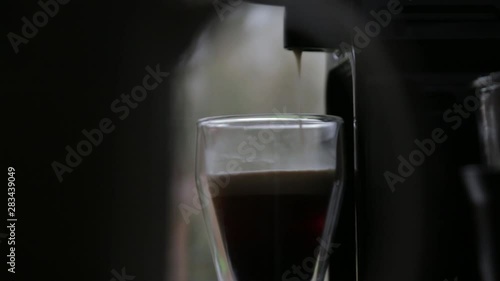 A cup of coffee filling up, ready to be enjoyed photo