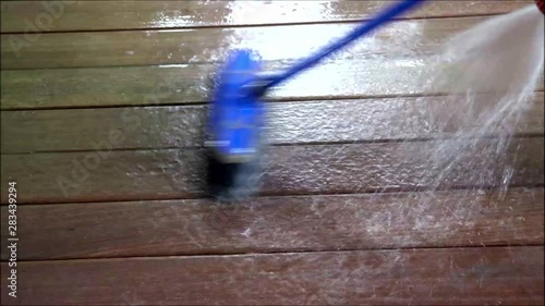Cleaning the iroko wood floor with a brush. photo