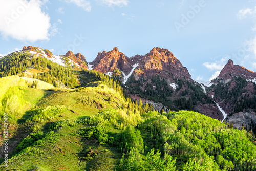 Maroon Bells red cliffs in Aspen, Colorado during blue hour sunrise with rocky mountain peak in early summer