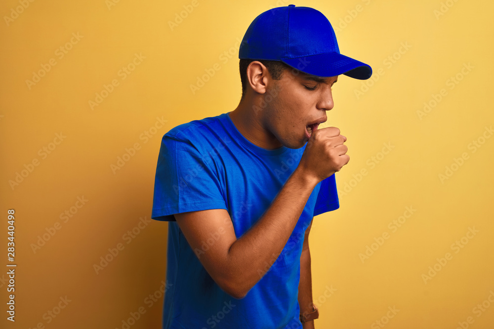 Young handsome arab delivery man standing over isolated yellow background feeling unwell and coughing as symptom for cold or bronchitis. Healthcare concept.