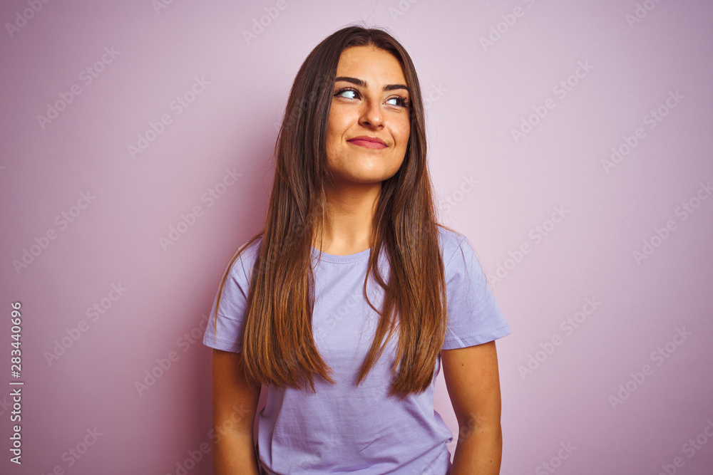 Obraz premium Young beautiful woman wearing casual t-shirt standing over isolated pink background smiling looking to the side and staring away thinking.