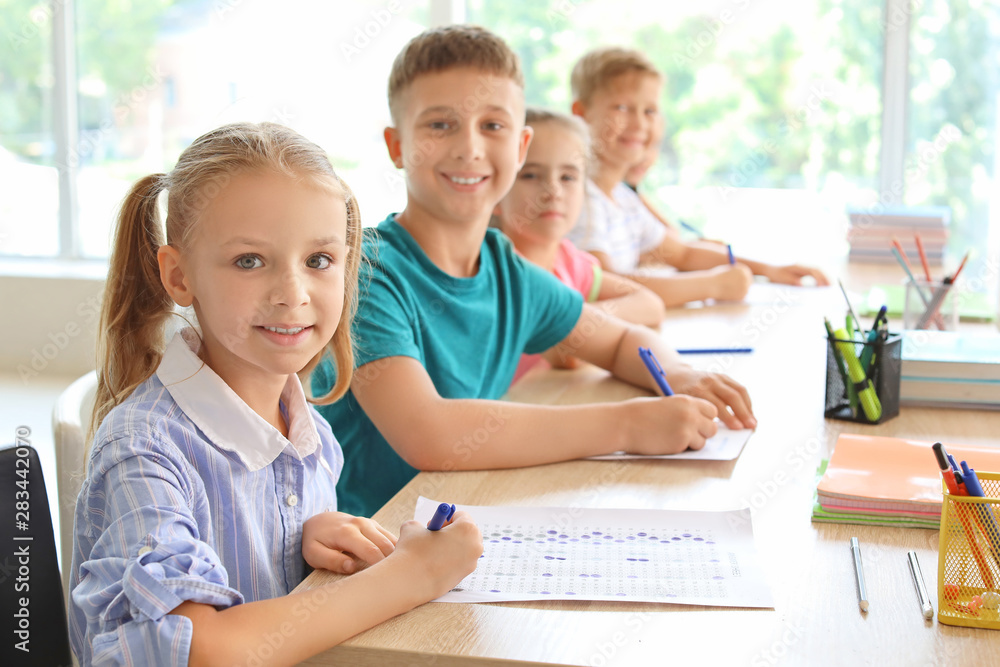 Pupils passing school test in classroom Pupils passing school test in classroom