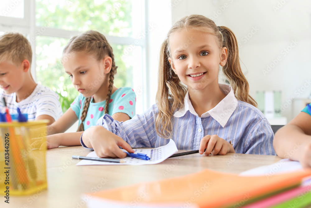 Pupils passing school test in classroom Pupils passing school test in classroom