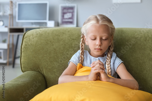 Little girl praying at home