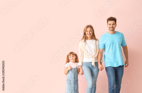 Portrait of happy family near color wall