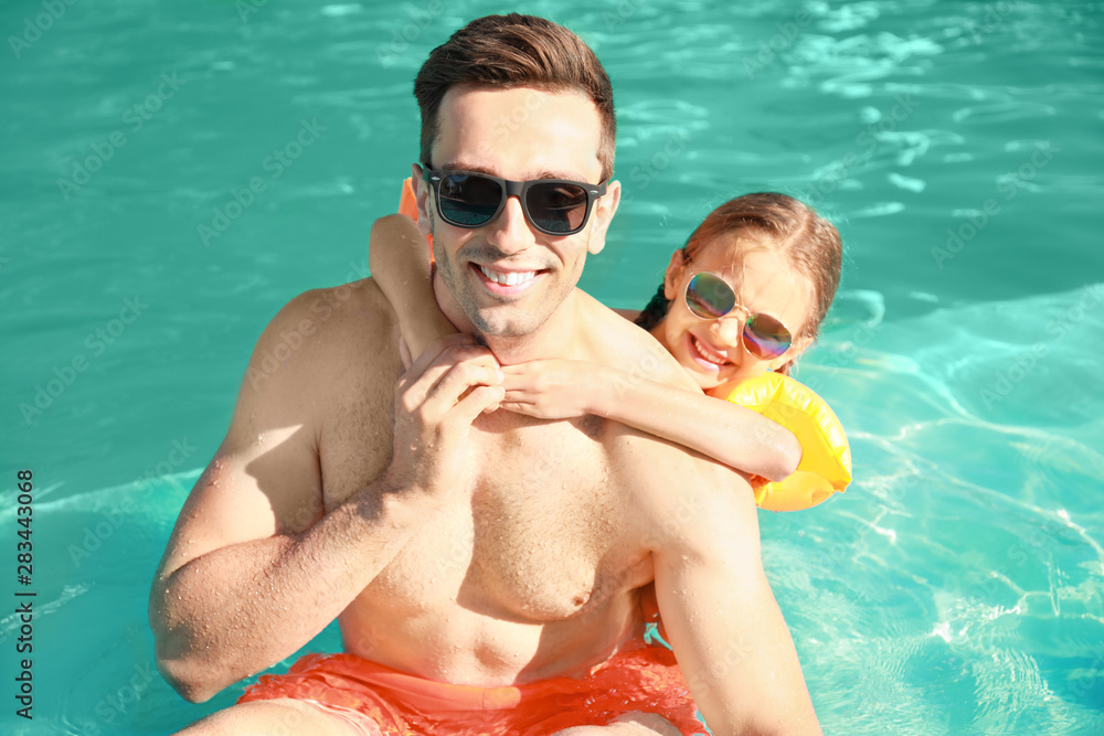 Father with little girl in swimming pool on summer day Father with little girl in swimming pool on summer day