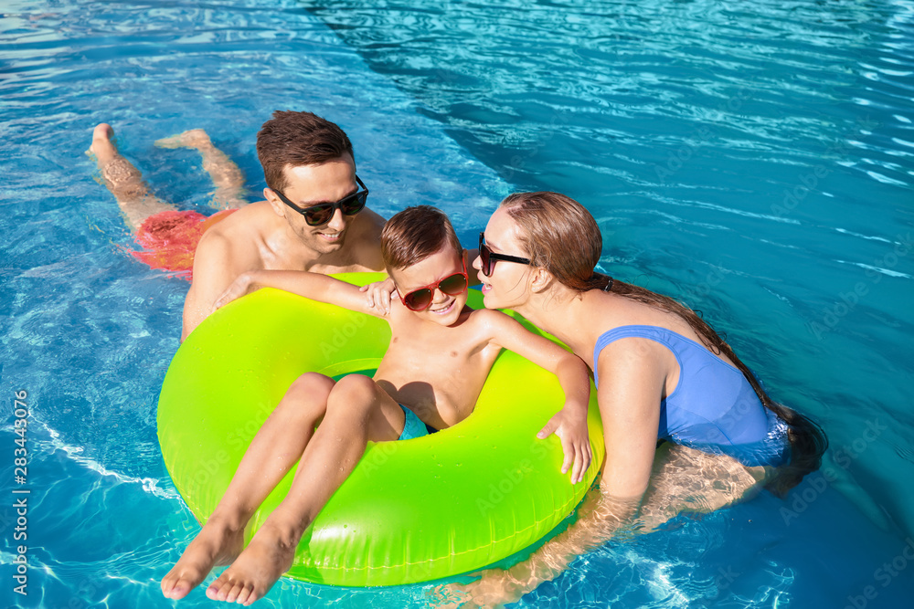 Happy family in swimming pool on summer day Happy family in swimming pool on summer day