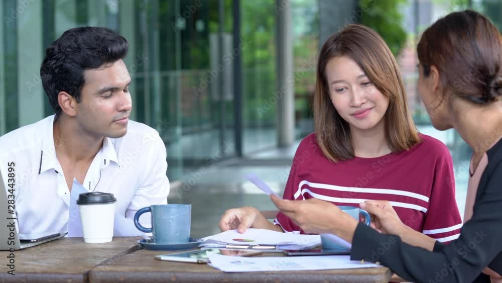 4K Medium shot of teamwork young businessman and businesswoman working together. Group of young adult asian businessman and businesswoman freelance discussion business together at coffee shop outdoors 4K Medium shot of teamwork young businessman and businesswoman working together. Group of young adult asian businessman and businesswoman freelance discussion business together at coffee shop outdoors