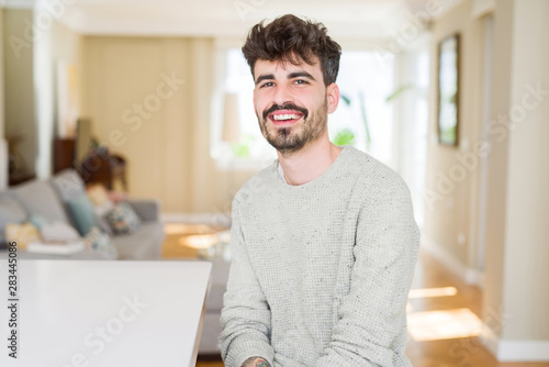 Handsome young man smiling cheerful at the camera with a big smile on face showing teeth