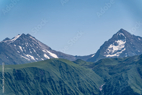 High mountains with green slopes and snowy peaks.