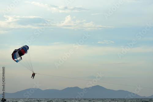 Parasailing on the background of the evening sky. Water activities on the coast of Vietnam