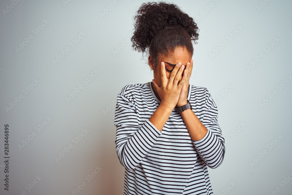 African american woman wearing navy striped t-shirt standing over isolated white background with sad expression covering face with hands while crying. Depression concept. African american woman wearing navy striped t-shirt standing over isolated white background with sad expression covering face with hands while crying. Depression concept.