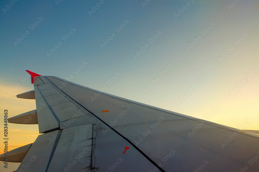 Fototapeta premium Flying and traveling, view from airplane window on the wing on sunset time