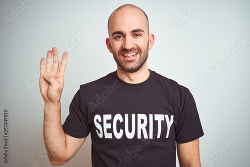 Young safeguard man wearing security uniform over isolated background showing and pointing up with fingers number four while smiling confident and happy.