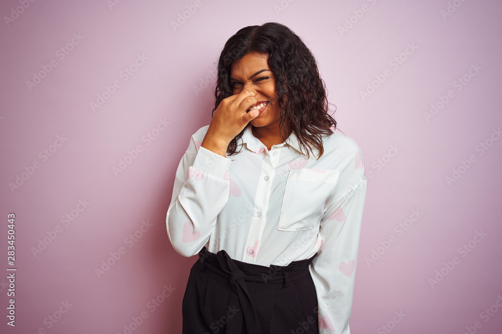 Transsexual transgender businesswoman standing over isolated pink background smelling something stinky and disgusting, intolerable smell, holding breath with fingers on nose. Bad smells concept. Transsexual transgender businesswoman standing over isolated pink background smelling something stinky and disgusting, intolerable smell, holding breath with fingers on nose. Bad smells concept.