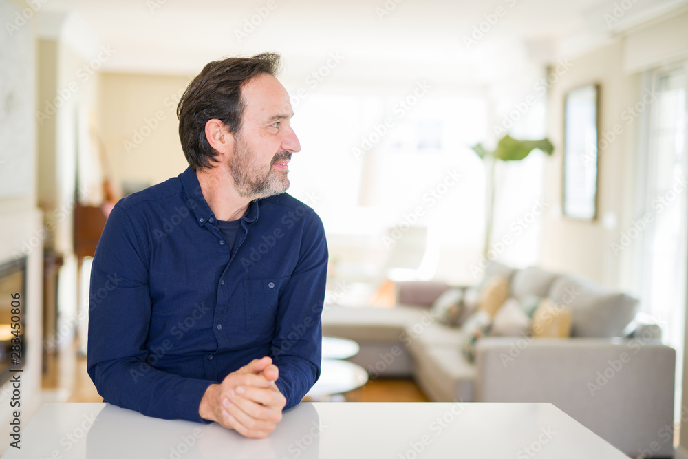 Handsome middle age man at home looking to side, relax profile pose with natural face with confident smile. Handsome middle age man at home looking to side, relax profile pose with natural face with confident smile.
