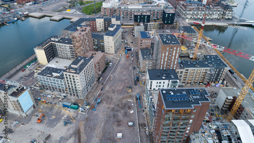 Construction site background. Hoisting cranes and new multi-storey buildings at day time. Industrial background. Sompasaari, Helsinki,Finland photo