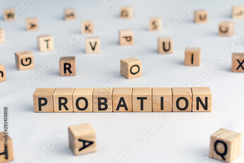 probation - word from wooden blocks with letters, time criminal is allowed to stay out of prison or period a new employee is suitable for work concept, random letters around, white  background photo